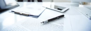 Documents, stylo et outils de travail sur une table de réunion